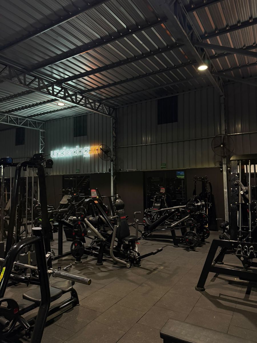 Sala principal del gimnasio con el cartel de neón de underdog.fit